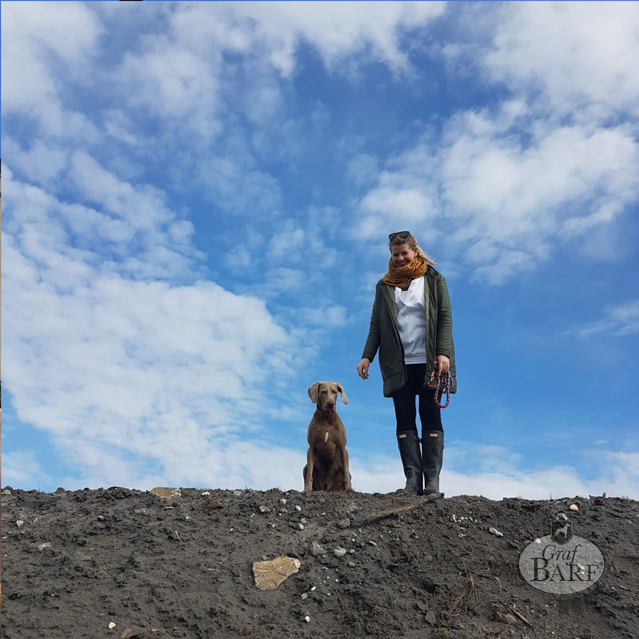 Waua Miaua Frau mit Hund steht auf einem Hügel