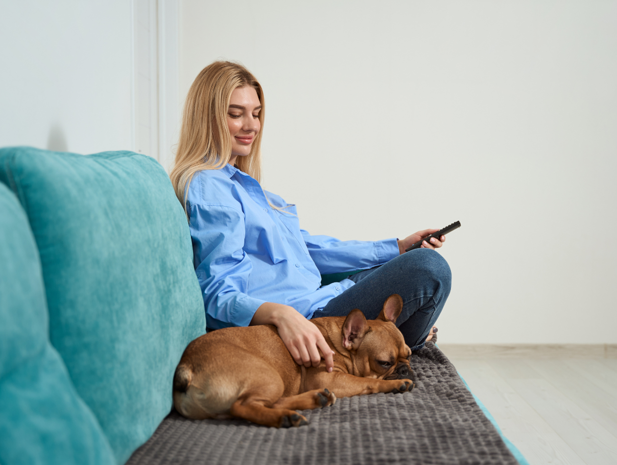 Ausruhen Blonde Frau sitzt mit schlafendem Hund auf Sofa