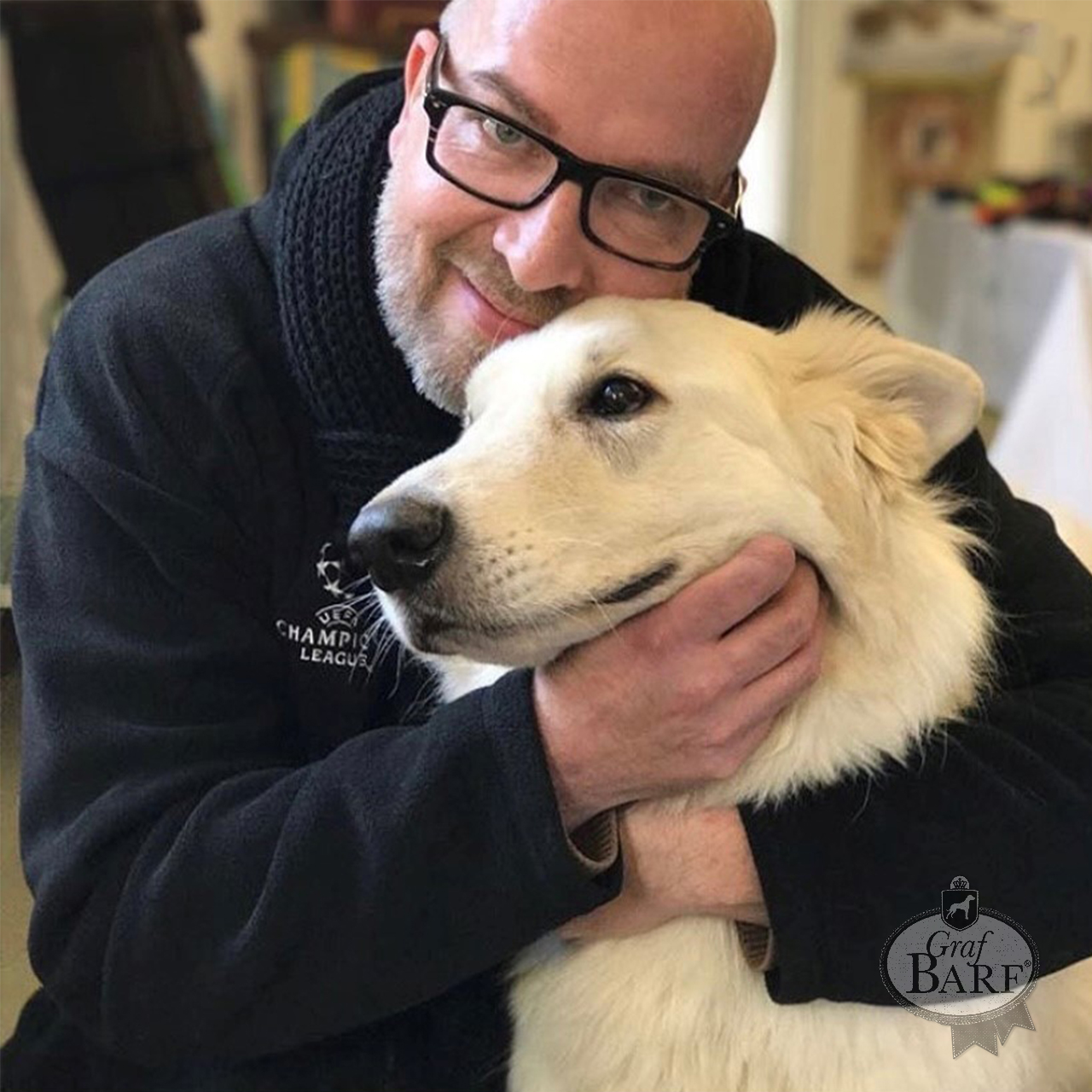 Omas Hundekekse Mann mit Bart umarmt weißen Hund